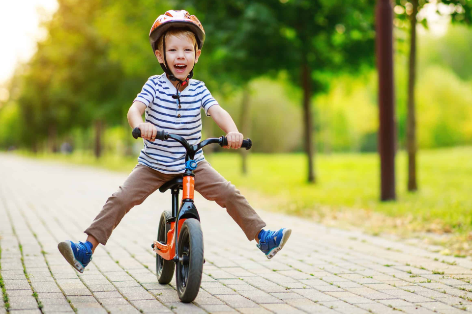Dieťa na bicykli v prírode pri škôlke